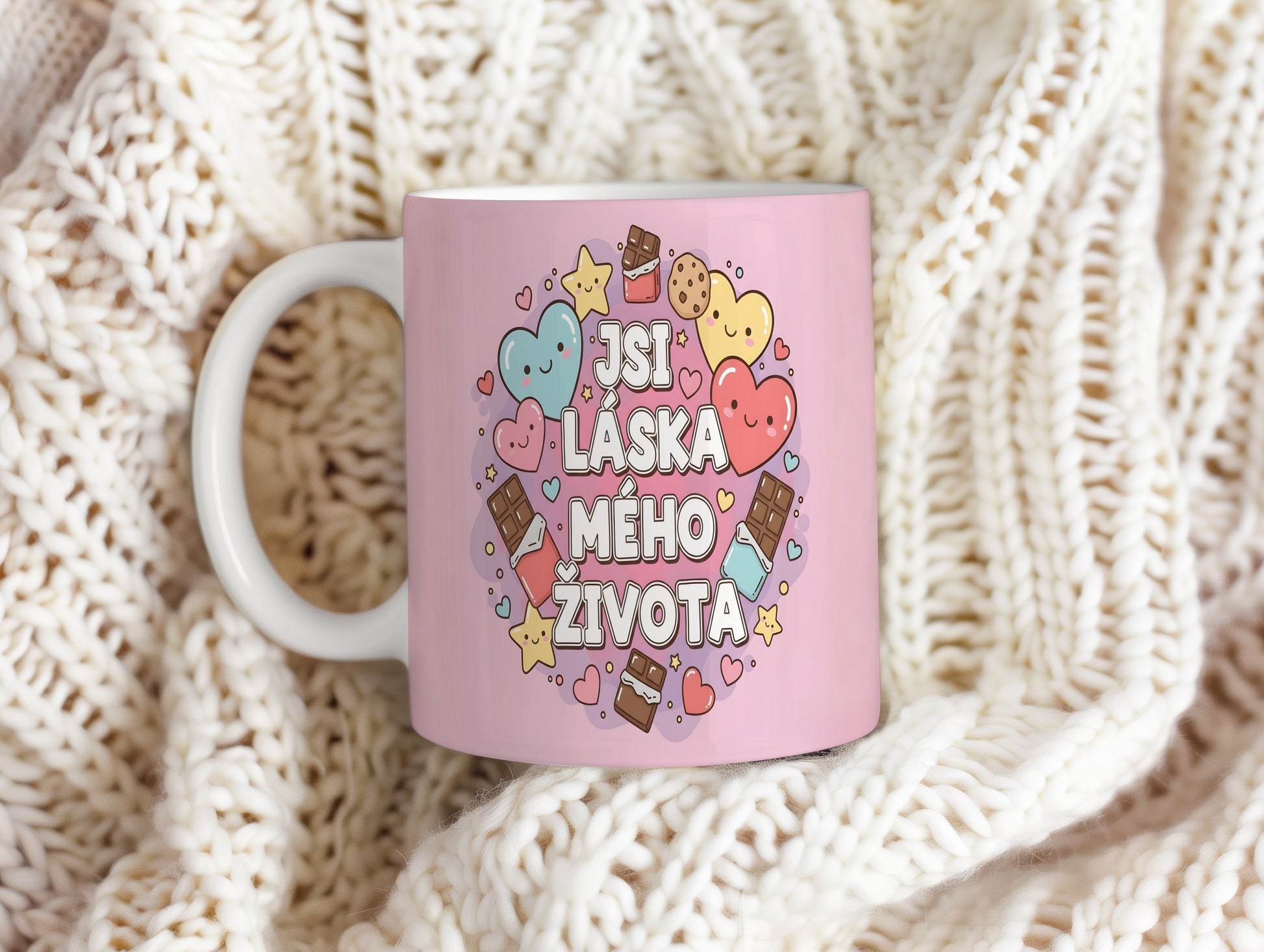Růžový hrnek s nápisem 'JSI LÁSKA MÉHO ŽIVOTA' a motivy srdcí a sladkostí.