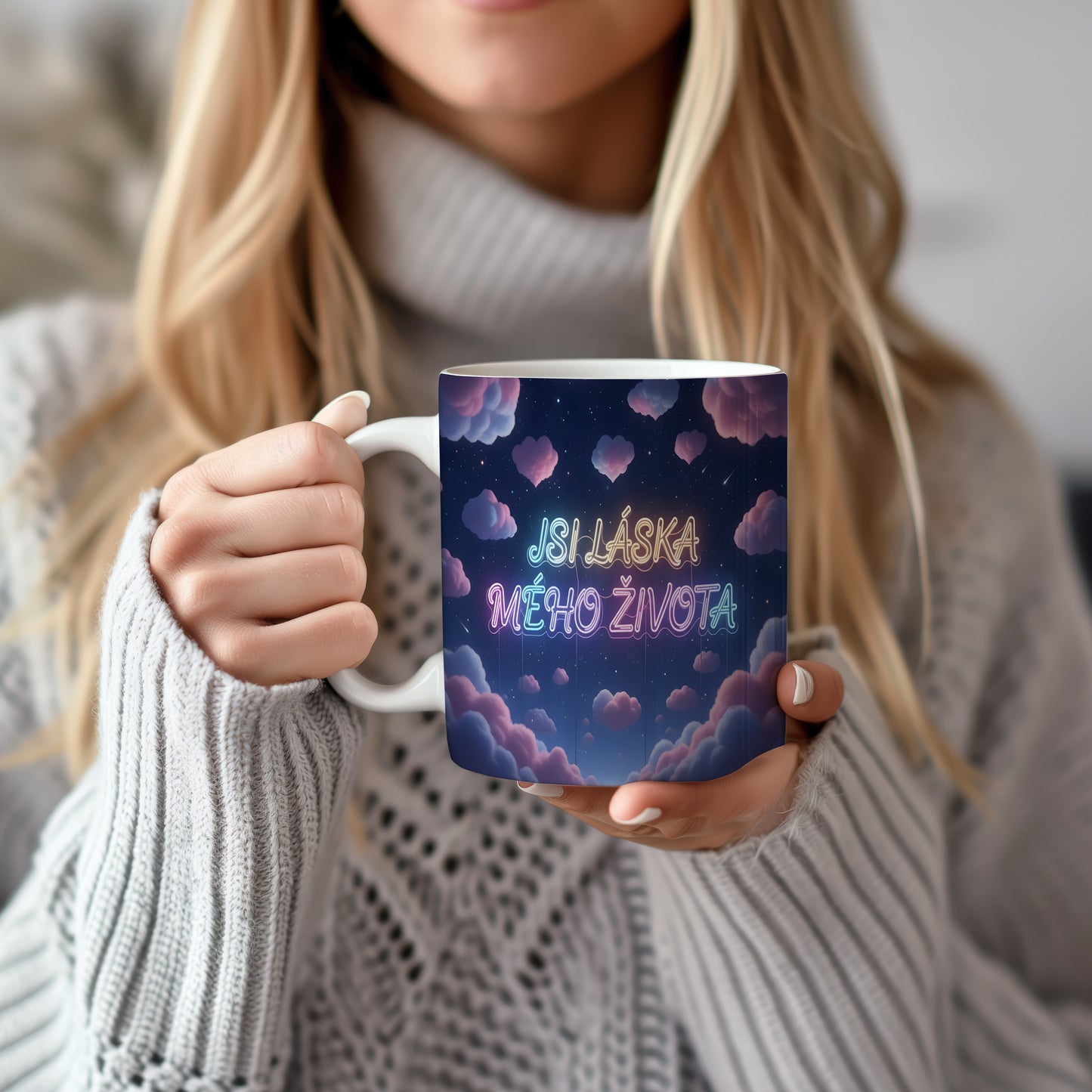 Hrnek s nápisem JSI LÁSKA MÉHO ŽIVOTA na hvězdné obloze s růžovými mraky.