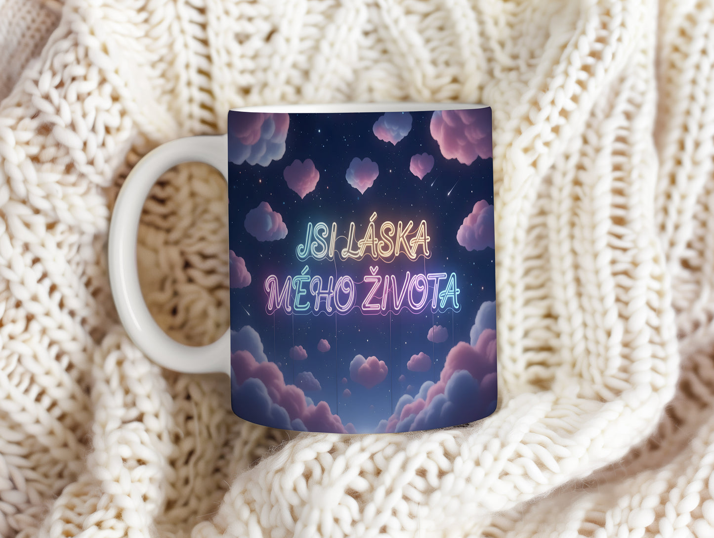 Hrnek s nápisem JSI LÁSKA MÉHO ŽIVOTA na hvězdné obloze s růžovými mraky.