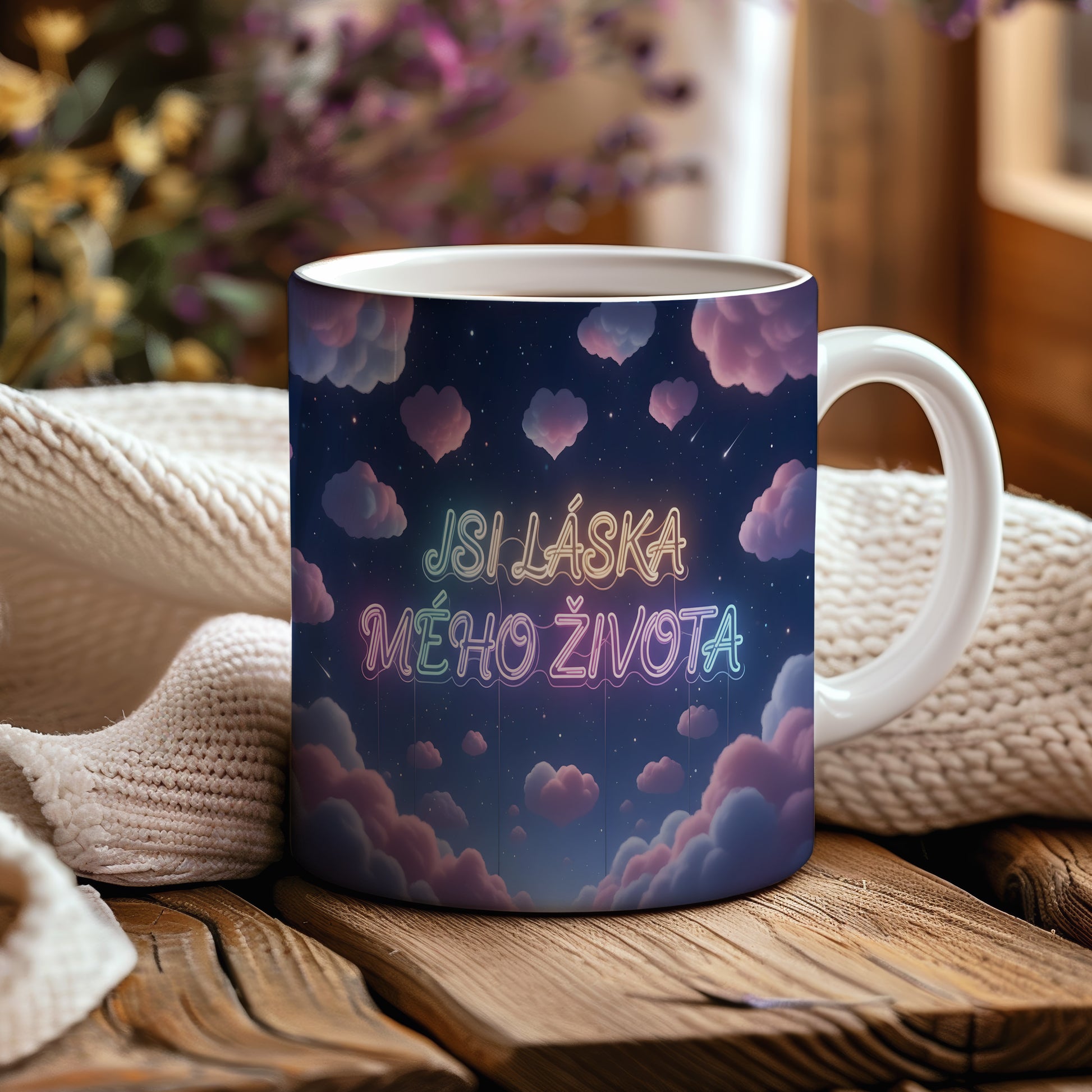 Hrnek s nápisem JSI LÁSKA MÉHO ŽIVOTA na hvězdné obloze s růžovými mraky.