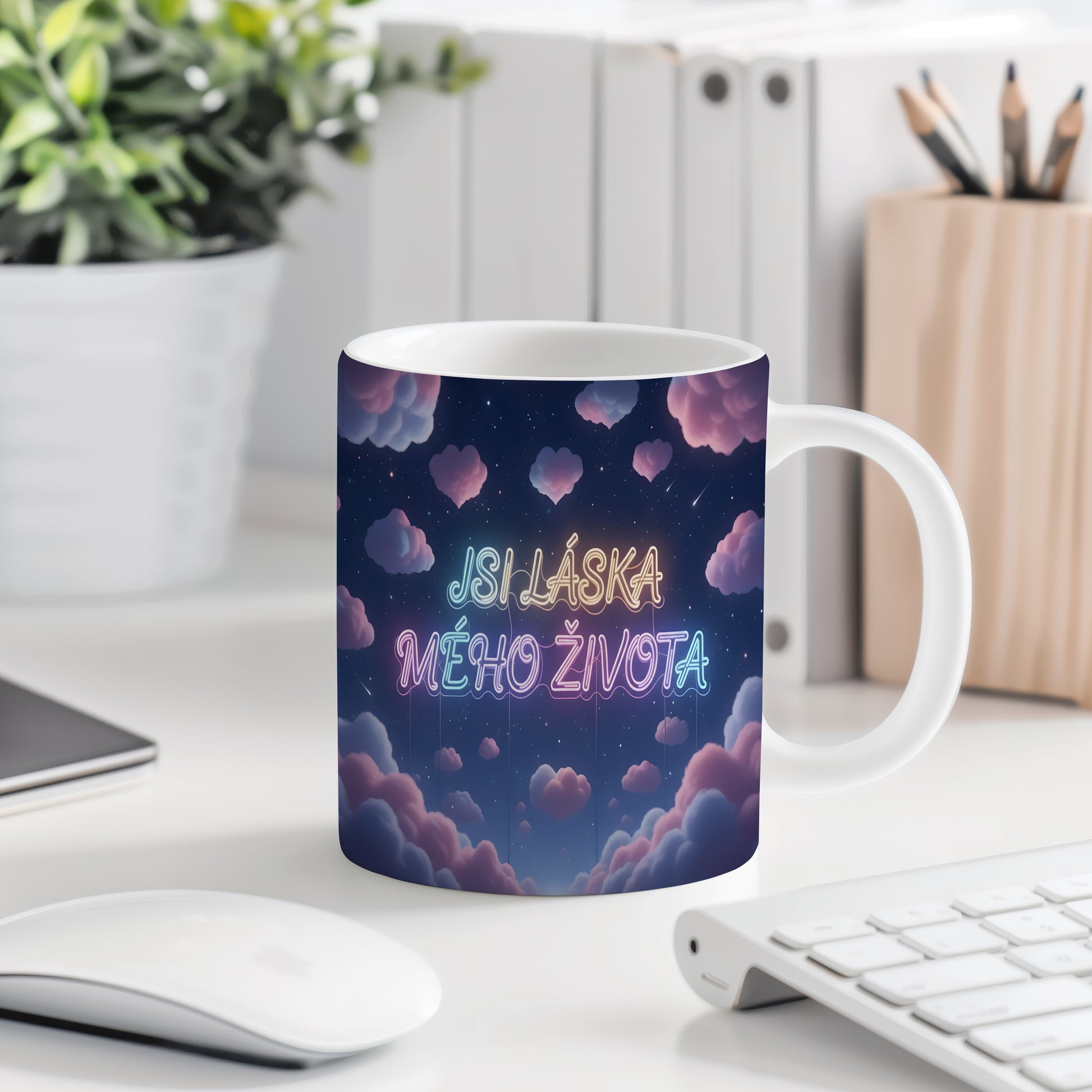 Hrnek s nápisem JSI LÁSKA MÉHO ŽIVOTA na hvězdné obloze s růžovými mraky.