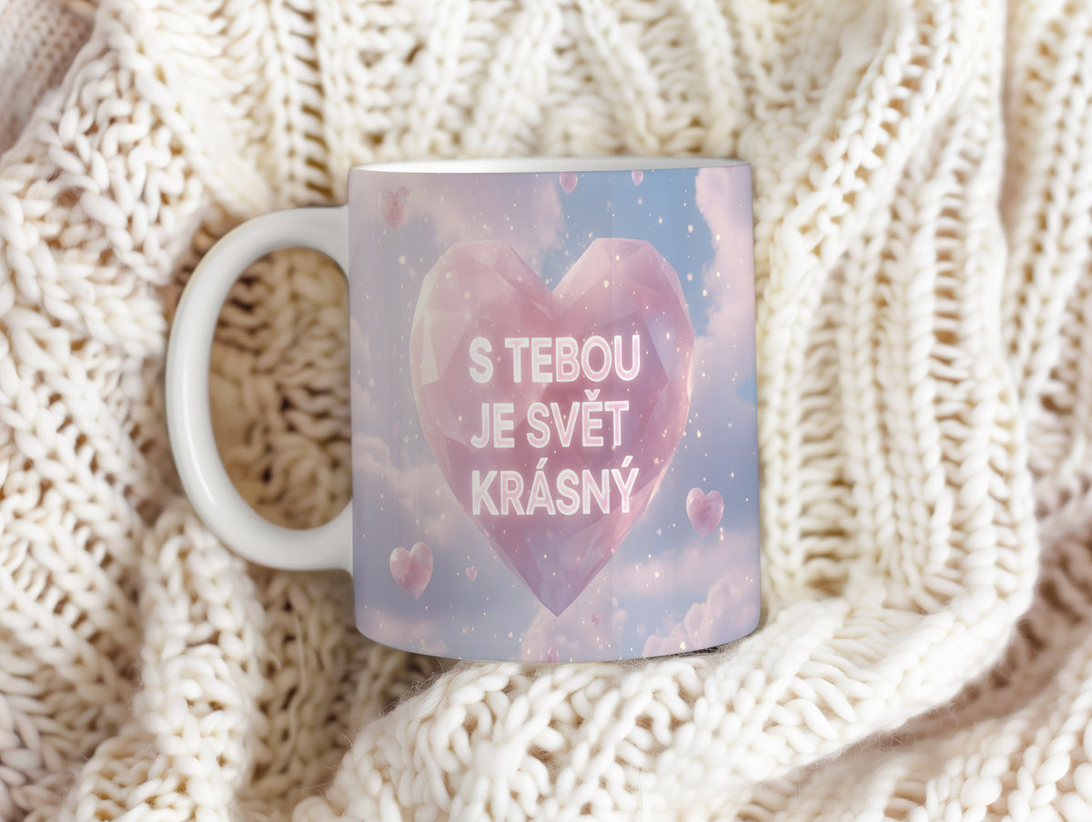 Hrnek s růžovým srdcem a nápisem 'S tebou je svět krásný' na pastelovém pozadí.