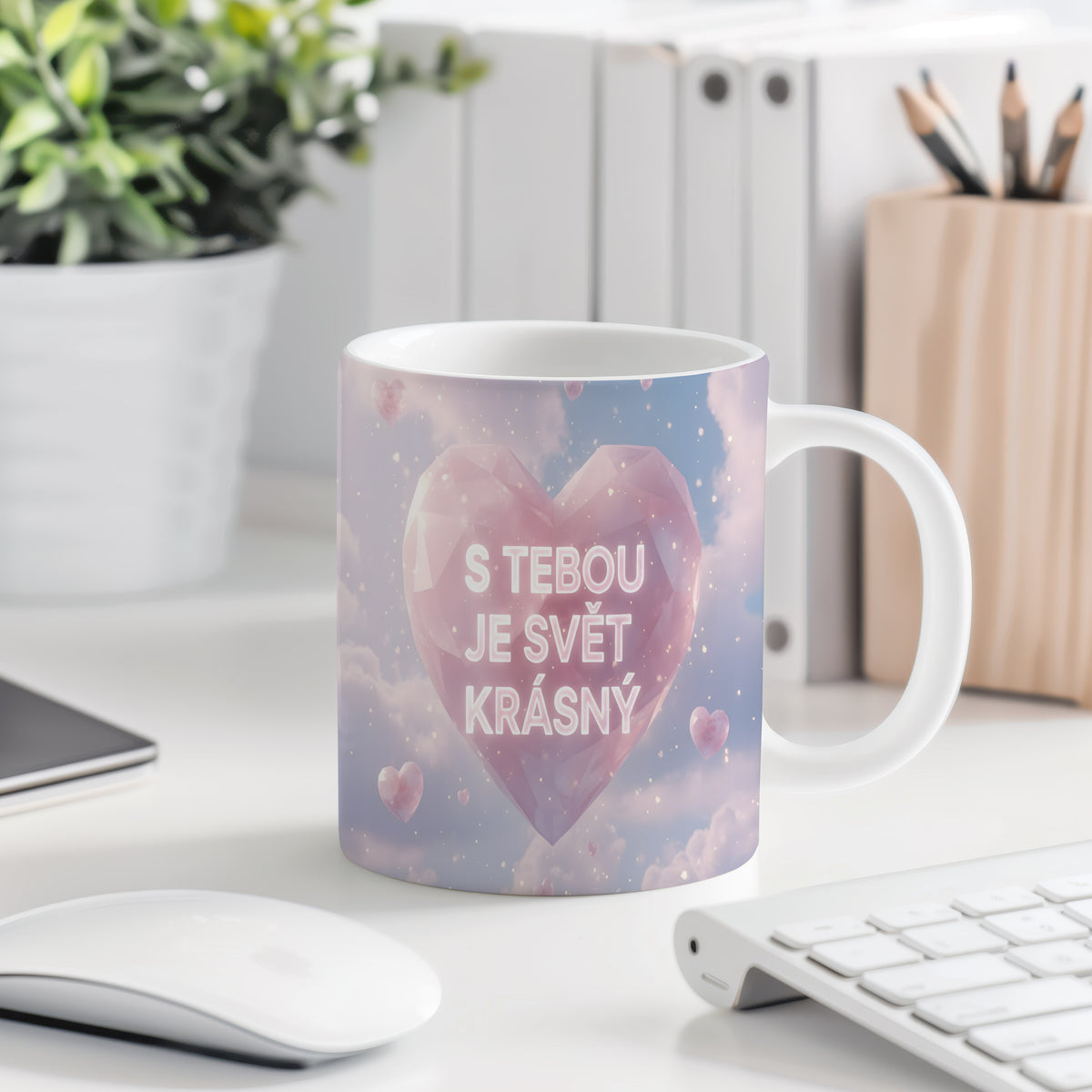 Hrnek s růžovým srdcem a nápisem 'S tebou je svět krásný' na pastelovém pozadí.