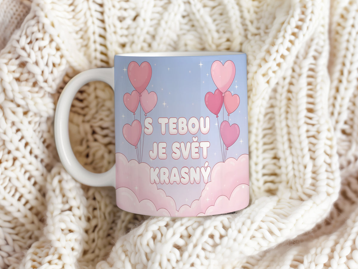 Hrnek s růžovými srdci a nápisem S tebou je svět krásný na pastelovém pozadí.