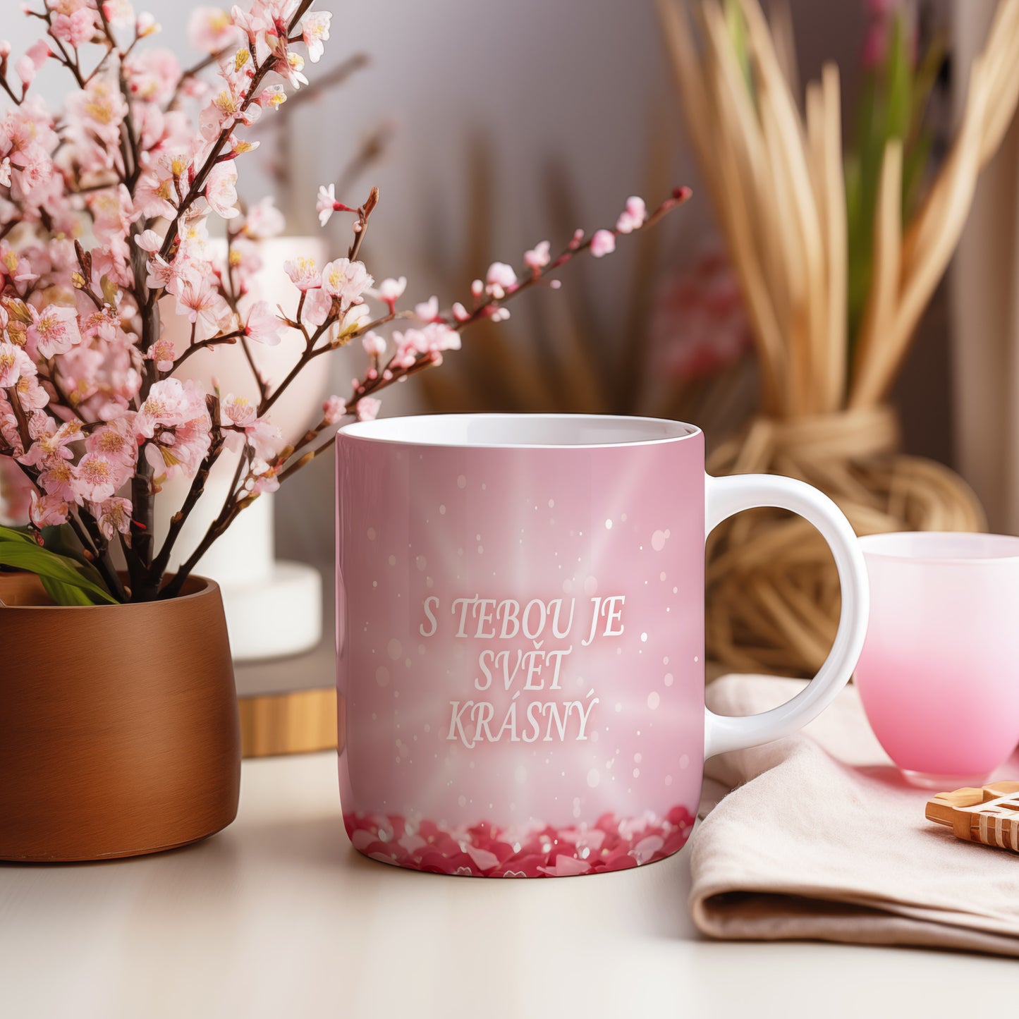 Růžový hrnek s nápisem S TEBOU JE SVĚT KRÁSNÝ a srdíčky.
