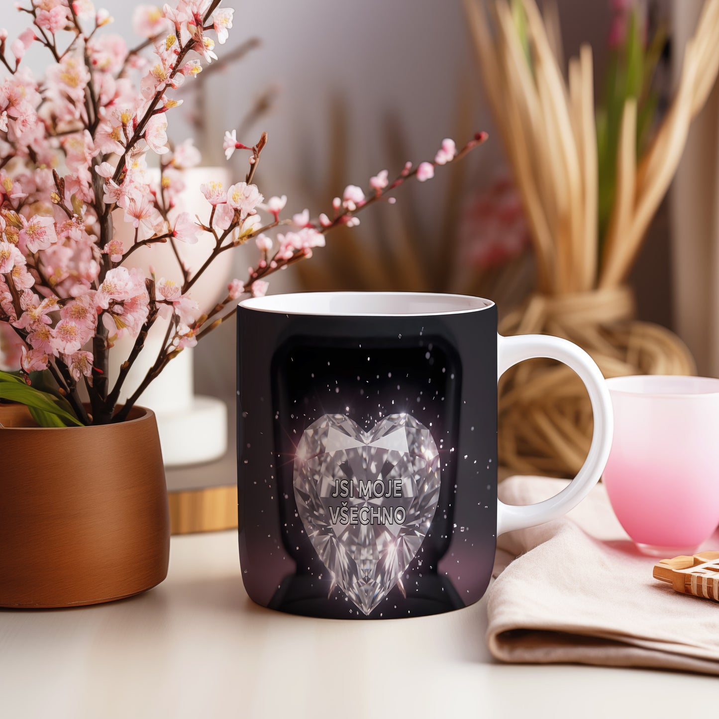 Hrnek s diamantovým srdcem a nápisem JSI MOJE VŠECHNO na černém pozadí.