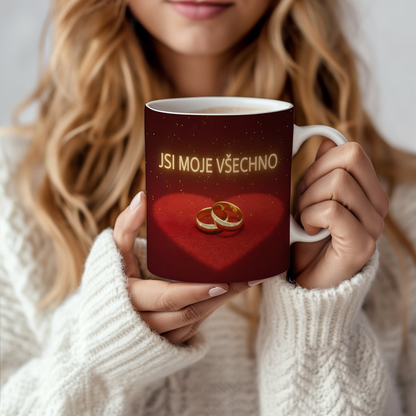 Červený hrnek s nápisem JSI MOJE VŠECHNO a zlatými prsteny na sametovém srdci.