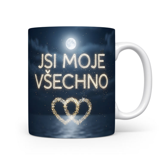 Hrnček s nápisem JSI MOJE VŠECHNO a zlatým srdcem na tmavě modrém pozadí.