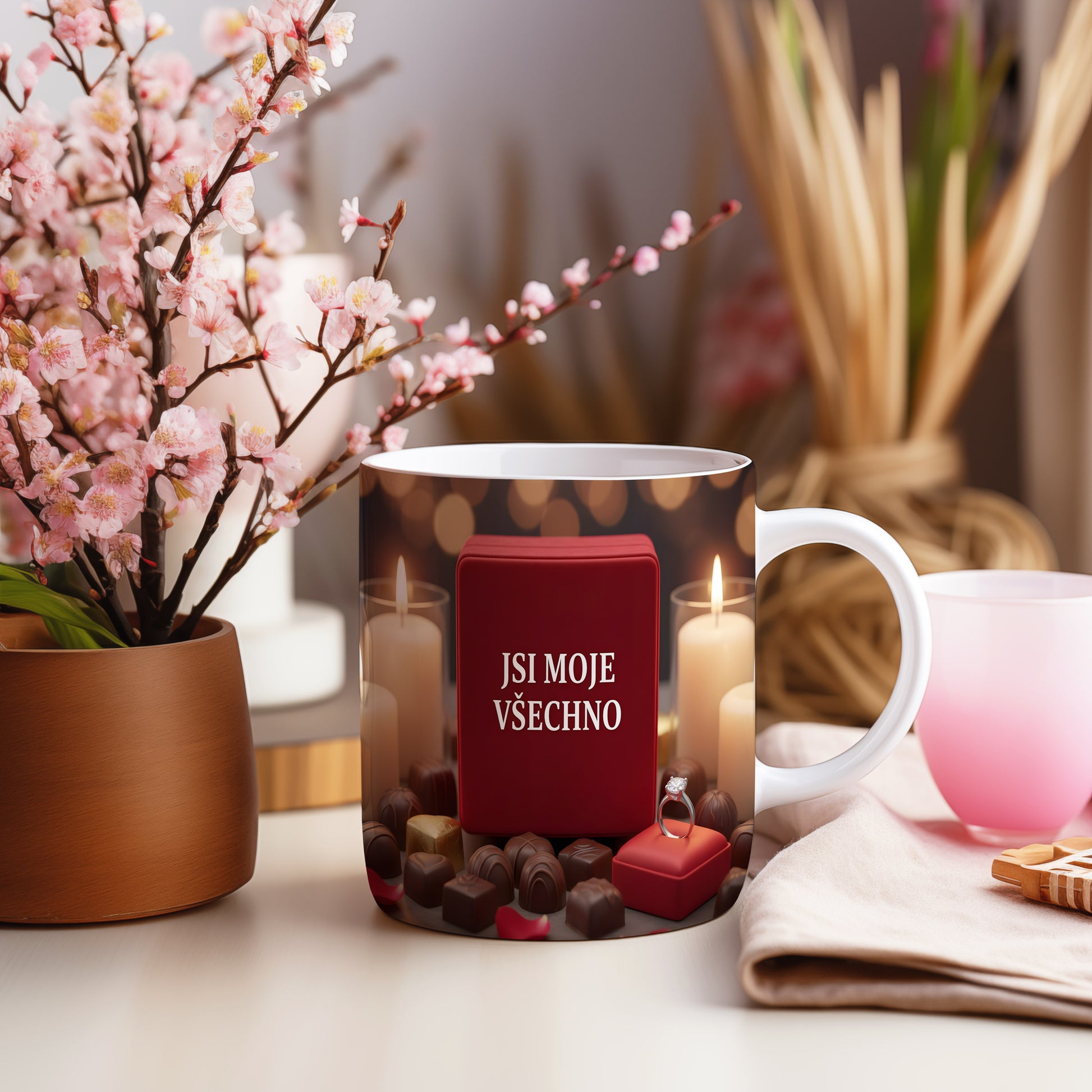 Romantický hrnek s nápisem JSI MOJE VŠECHNO, čokoládami a svíčkami.