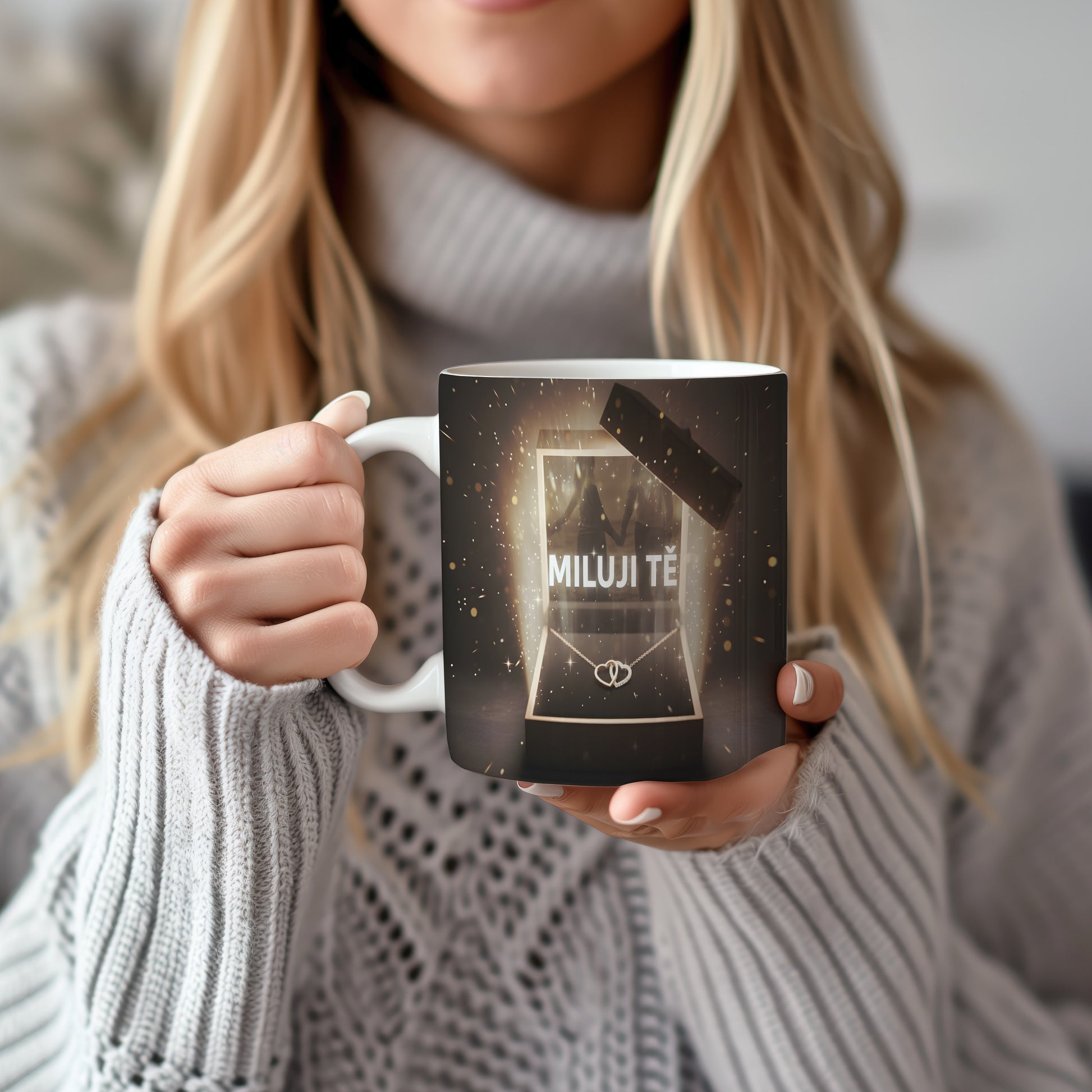 Hrnek s nápisem MILUJI TĚ a zlatými třpytkami na tmavém pozadí.