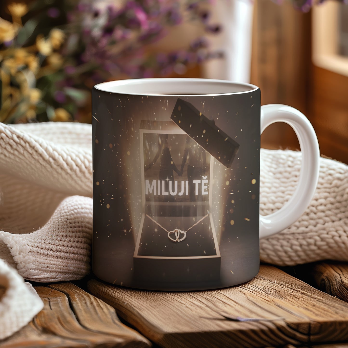 Hrnek s nápisem MILUJI TĚ a zlatými třpytkami na tmavém pozadí.