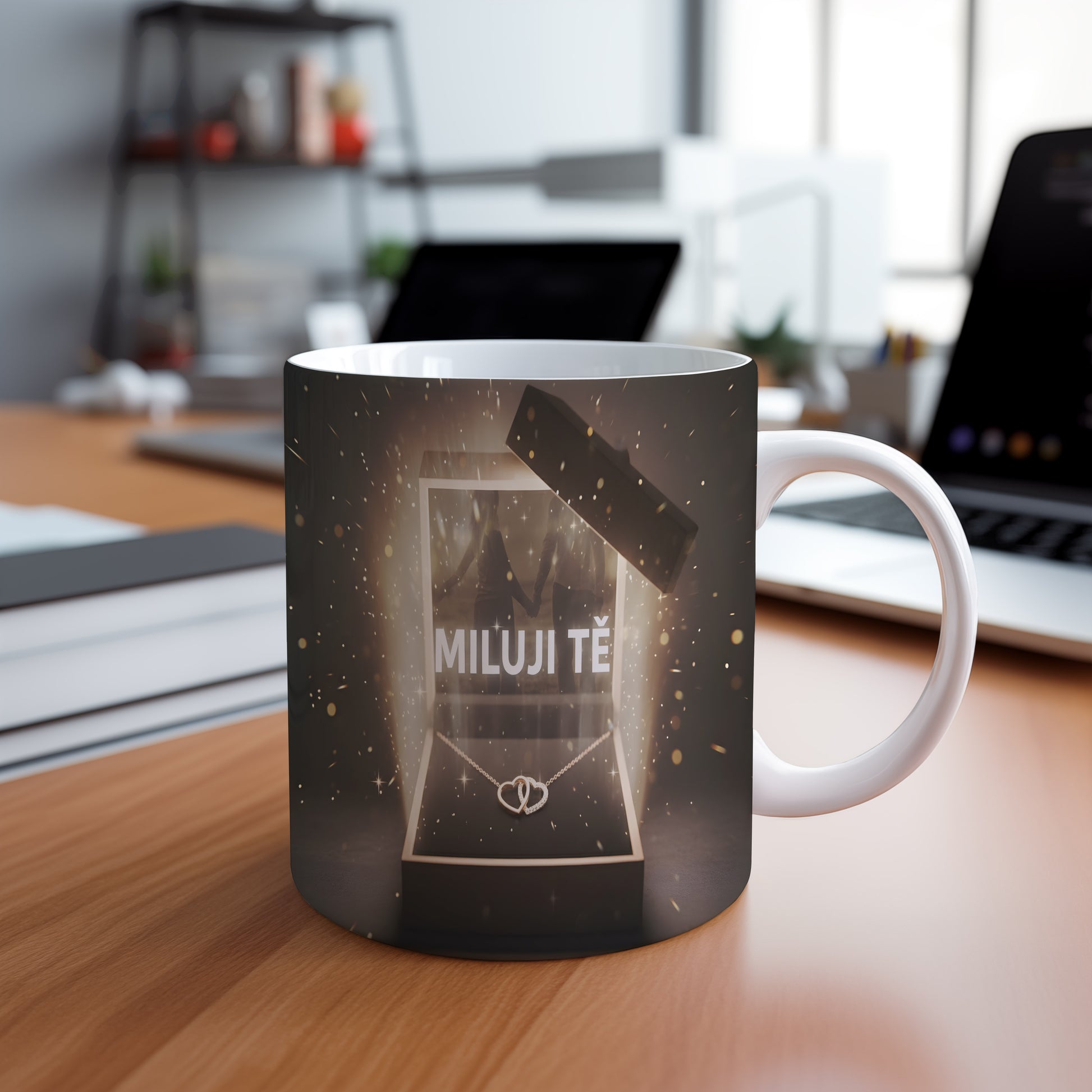 Hrnek s nápisem MILUJI TĚ a zlatými třpytkami na tmavém pozadí.