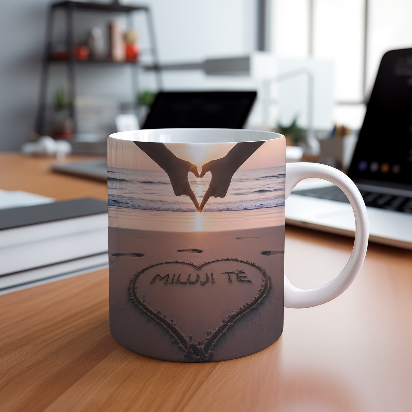 Hrnček s nápisem MILUJI TĚ na pláži při západu slunce.