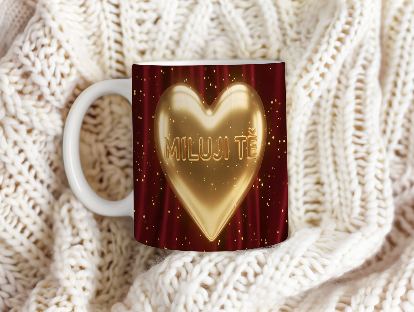 Hrnek s nápisem MILUJI TĚ a zlatým srdcem na červeném pozadí.