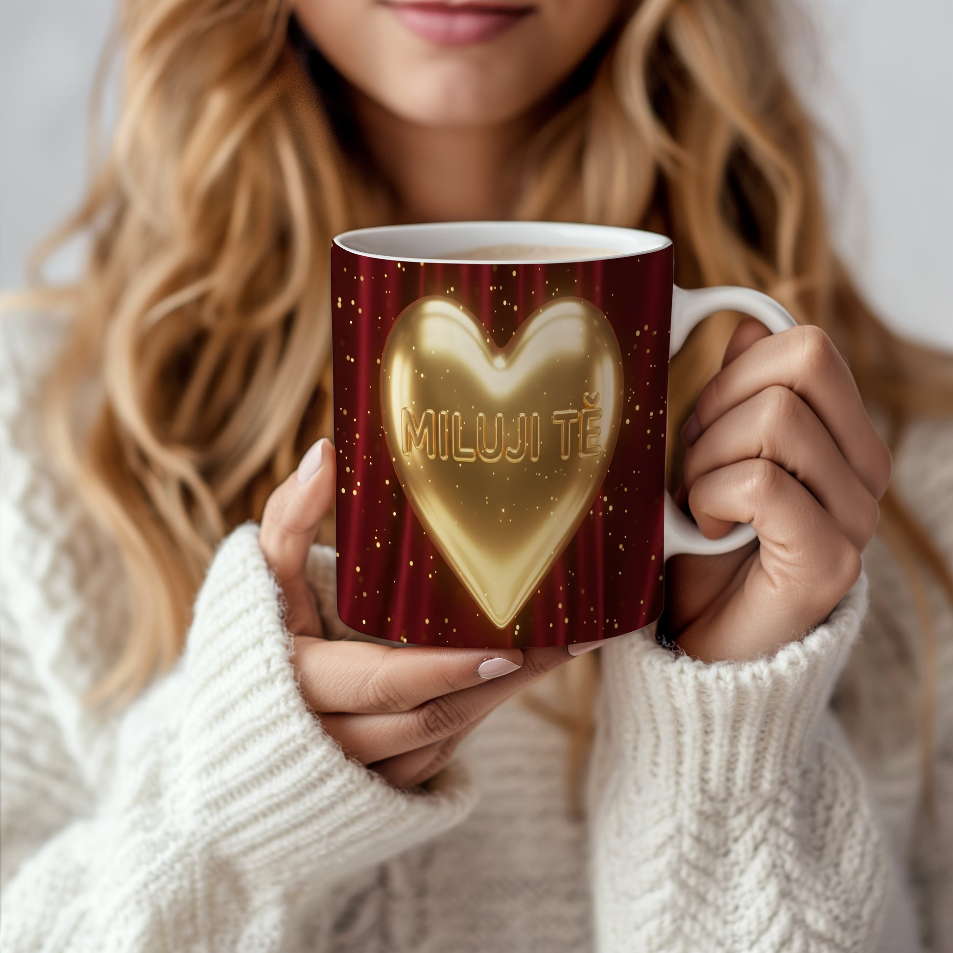 Hrnek s nápisem MILUJI TĚ a zlatým srdcem na červeném pozadí.