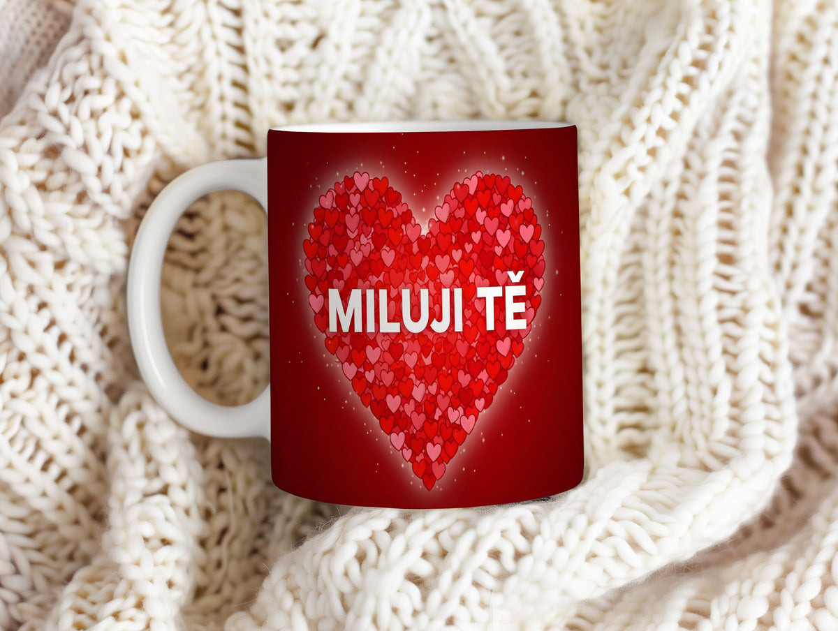 Červený hrnek s nápisem MILUJI TĚ a srdci.