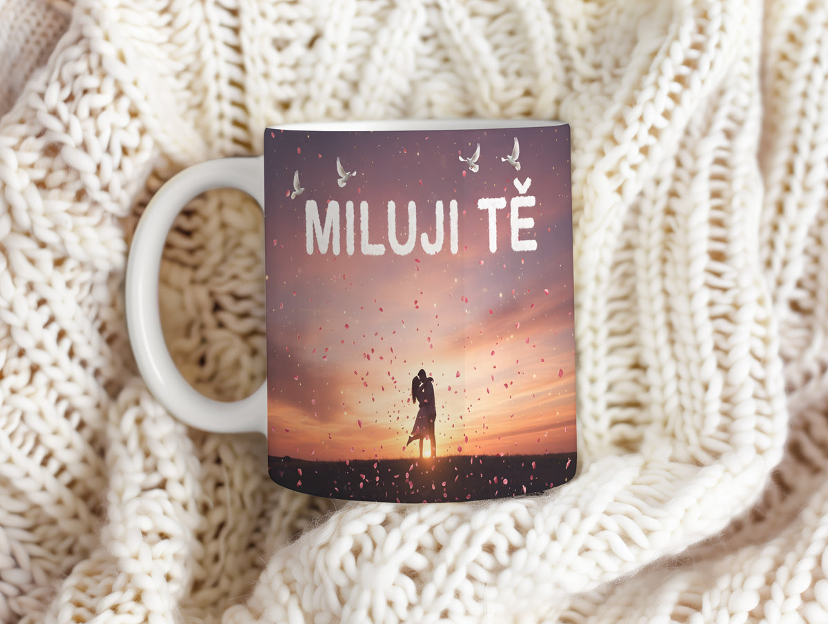 Hrnek s nápisem MILUJI TĚ, párem při západu slunce a okvětními lístky.