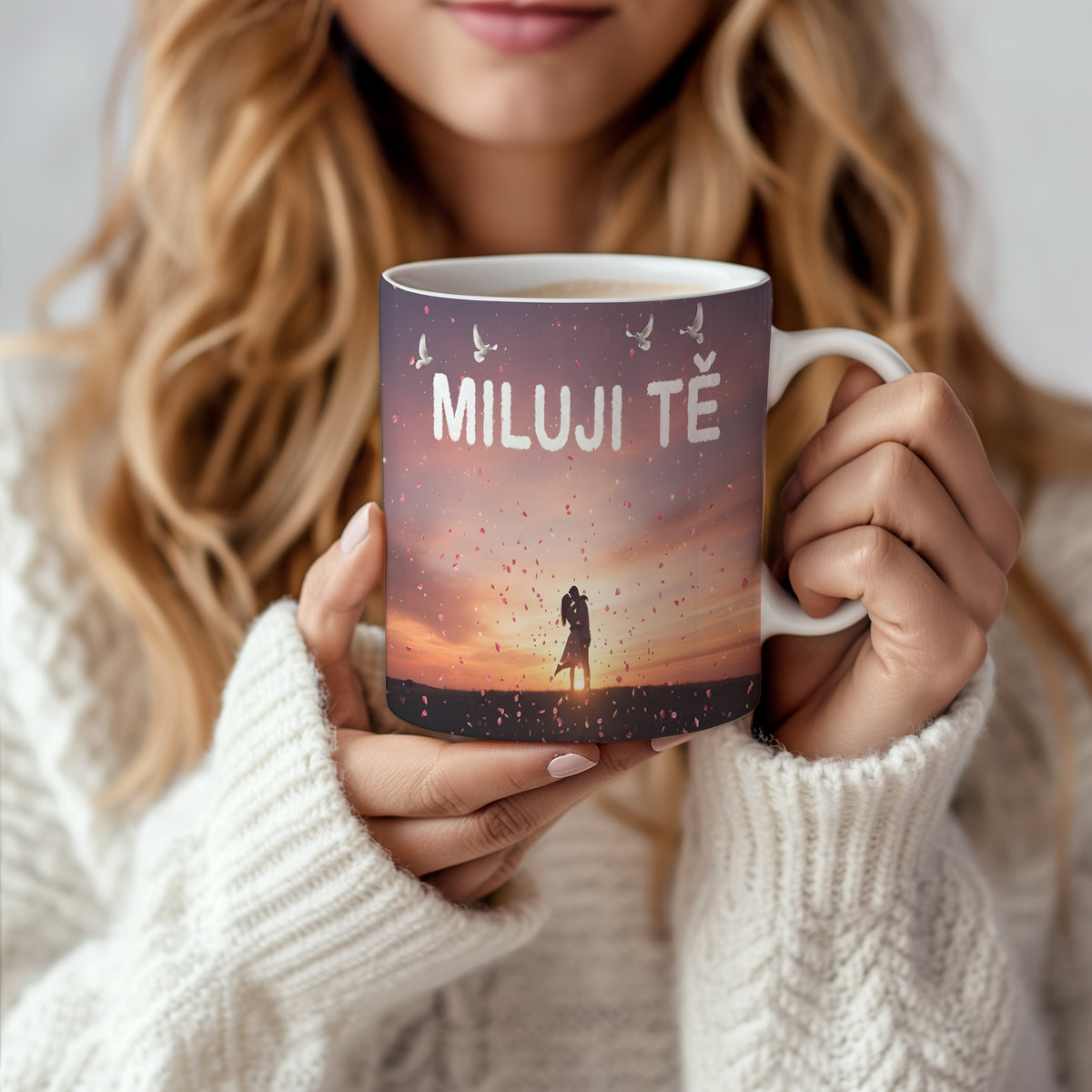 Hrnek s nápisem MILUJI TĚ, párem při západu slunce a okvětními lístky.