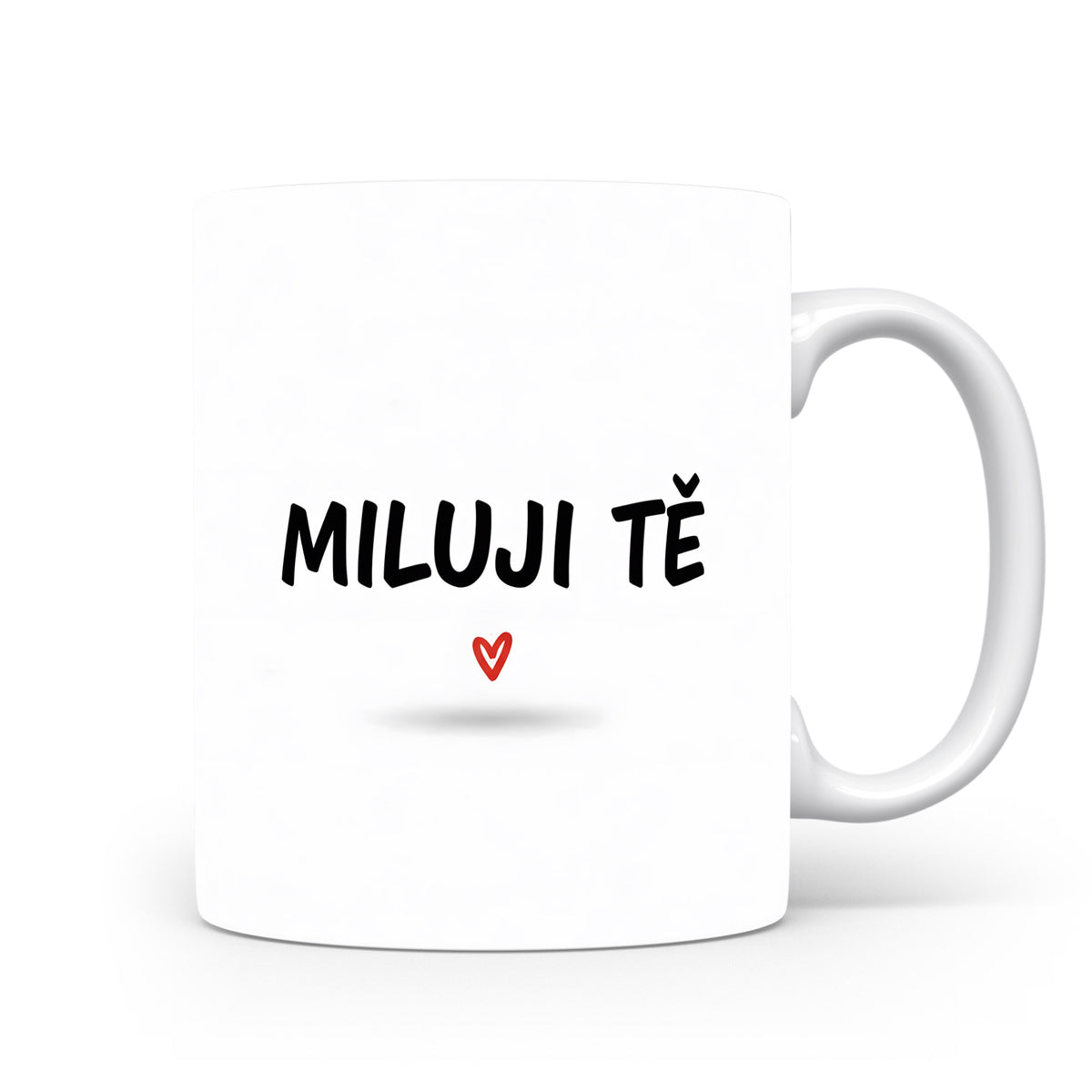 Bílý hrnek s nápisem MILUJI TĚ a červeným srdcem.