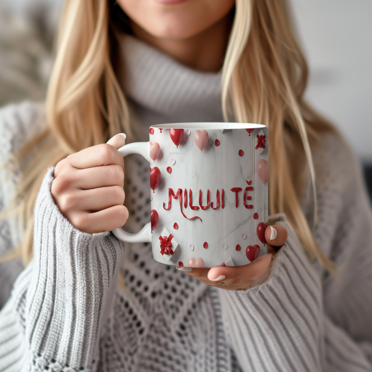 Hrnček s nápisem MILUJI TĚ na mramorovém pozadí s červenými a růžovými srdíčky.