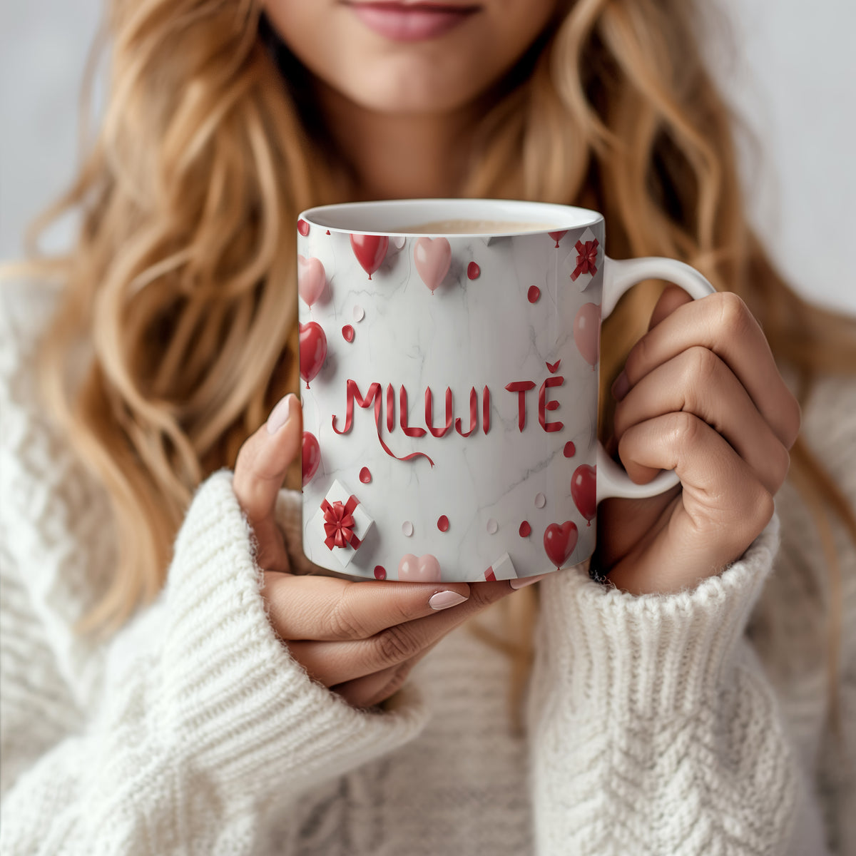 Hrnček s nápisem MILUJI TĚ na mramorovém pozadí s červenými a růžovými srdíčky.