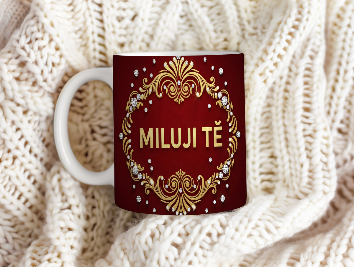 Červený hrnek se zlatými ornamenty a nápisem MILUJI TĚ.