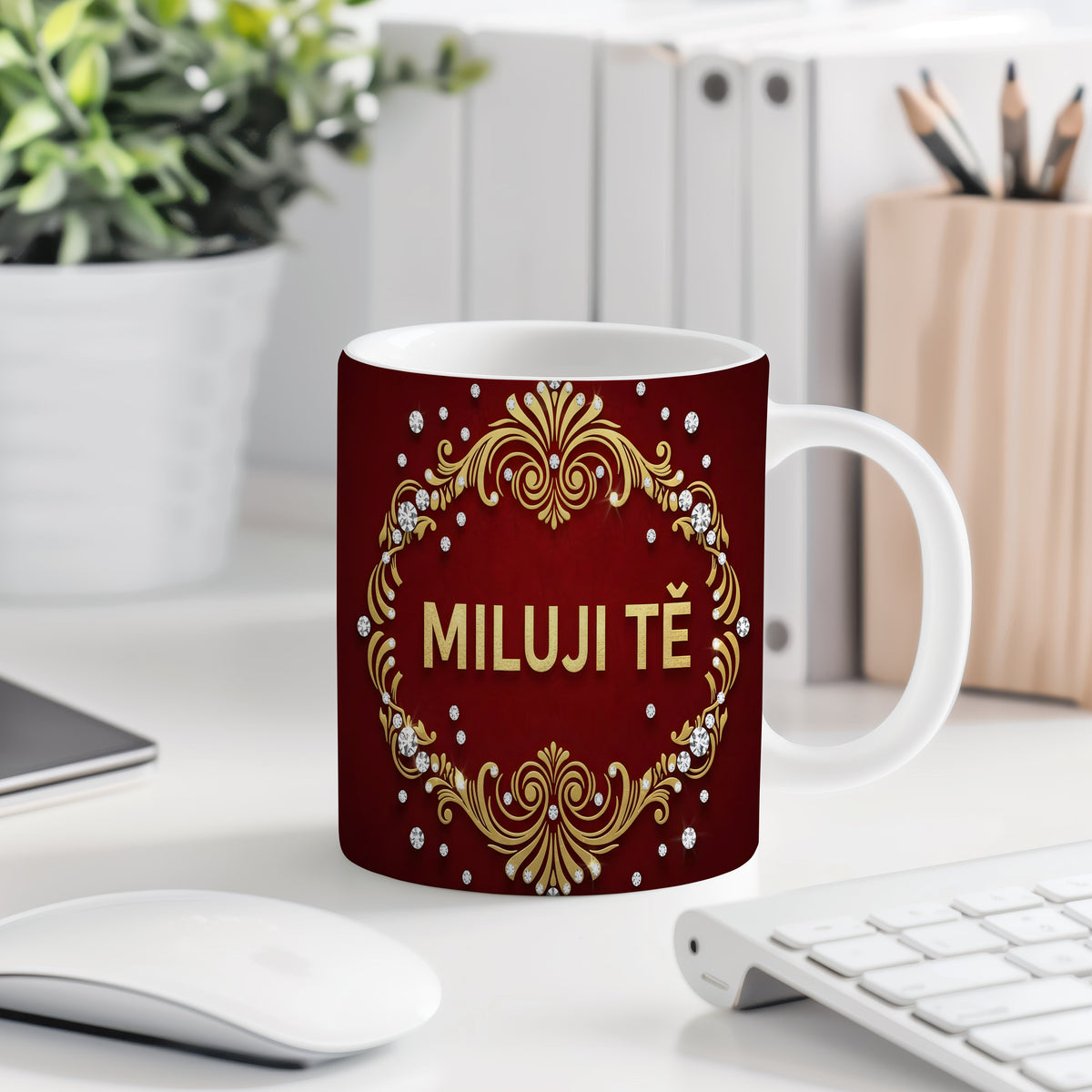 Červený hrnek se zlatými ornamenty a nápisem MILUJI TĚ.