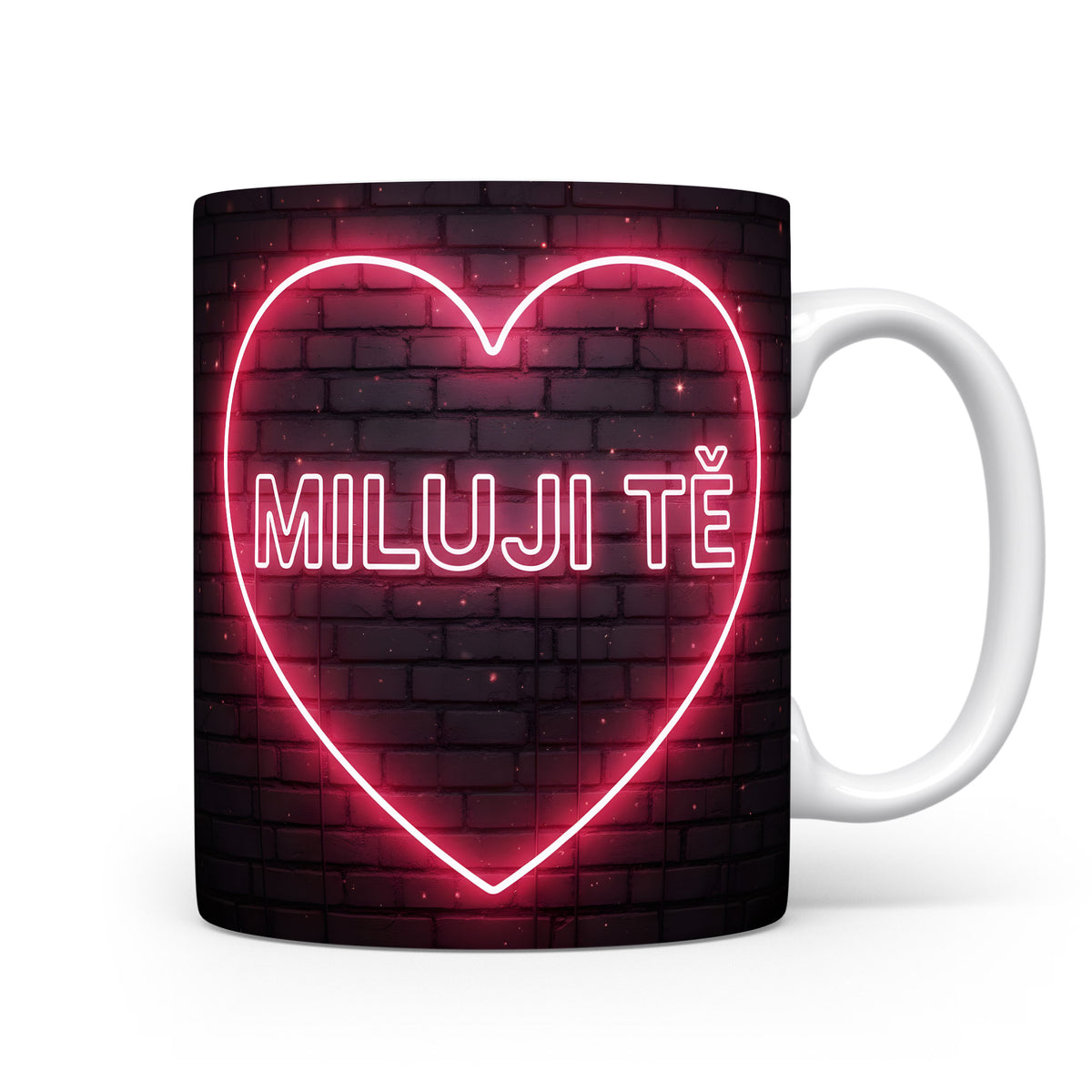 Hrnek s neonovým nápisem 'MILUJI TĚ' na cihlovém pozadí.