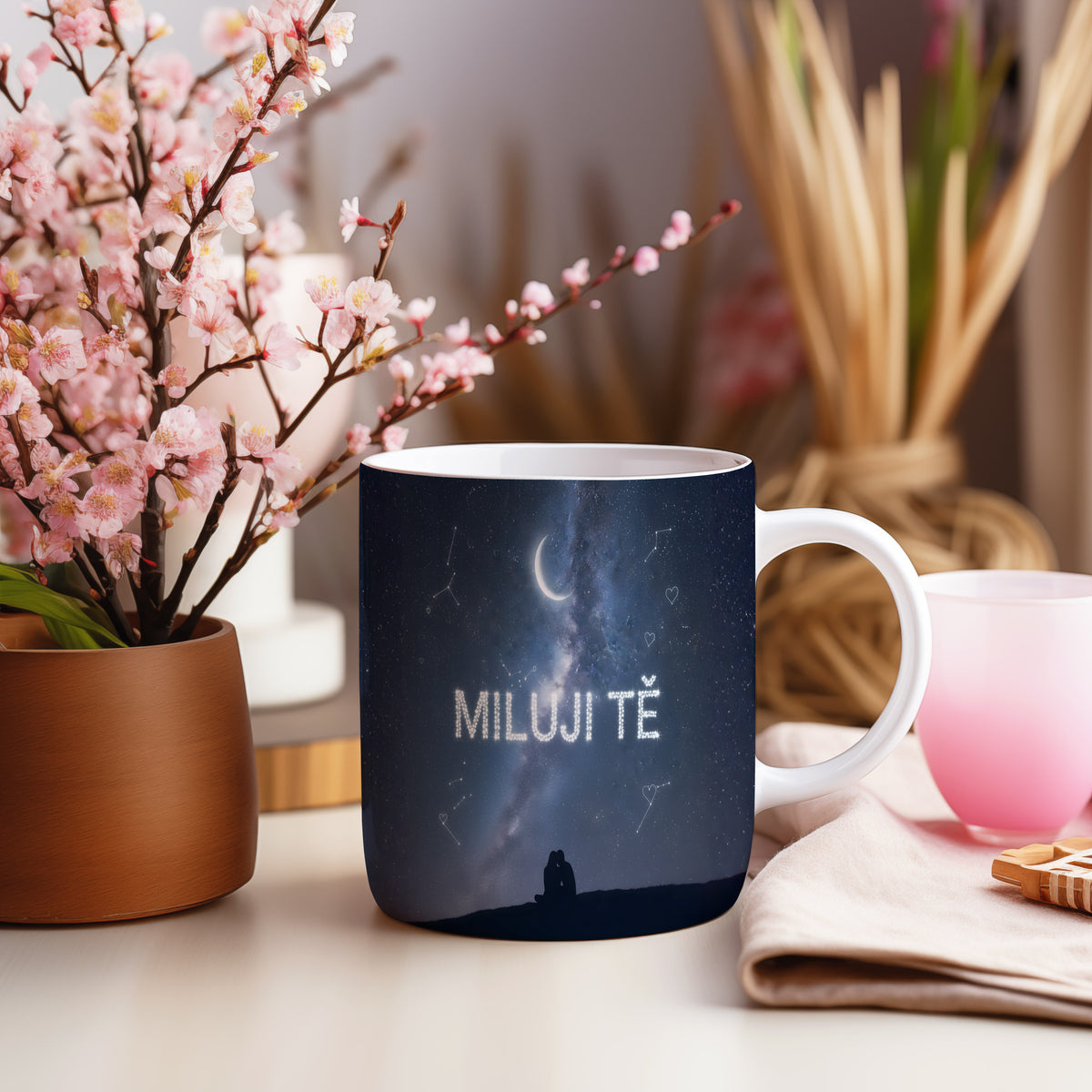 Hrnek s nápisem 'Miluji tě' a hvězdnou oblohou.