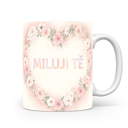 Hrnek s nápisem MILUJI TĚ a květinovým srdcem v pastelových barvách.