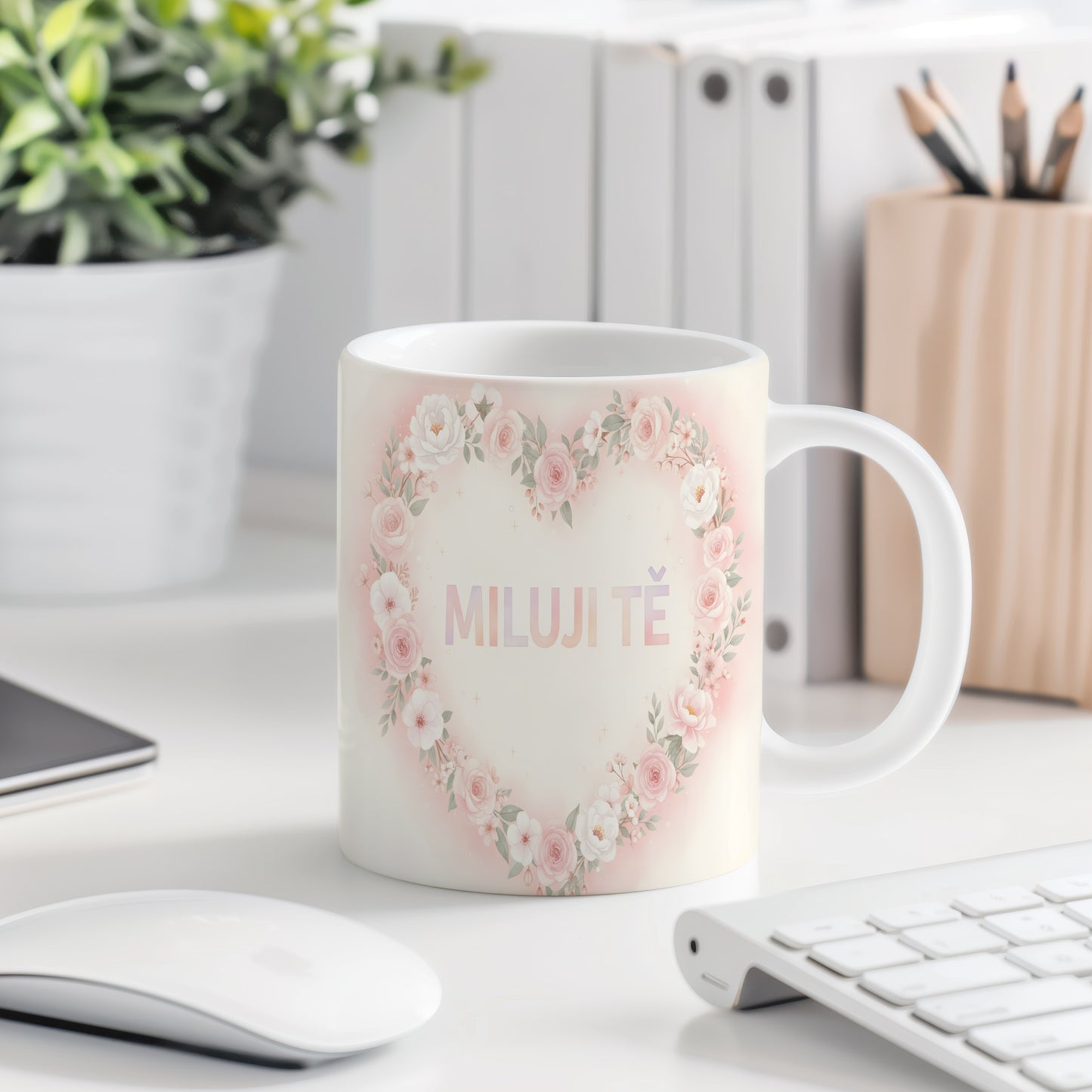 Hrnek s nápisem MILUJI TĚ a květinovým srdcem v pastelových barvách.