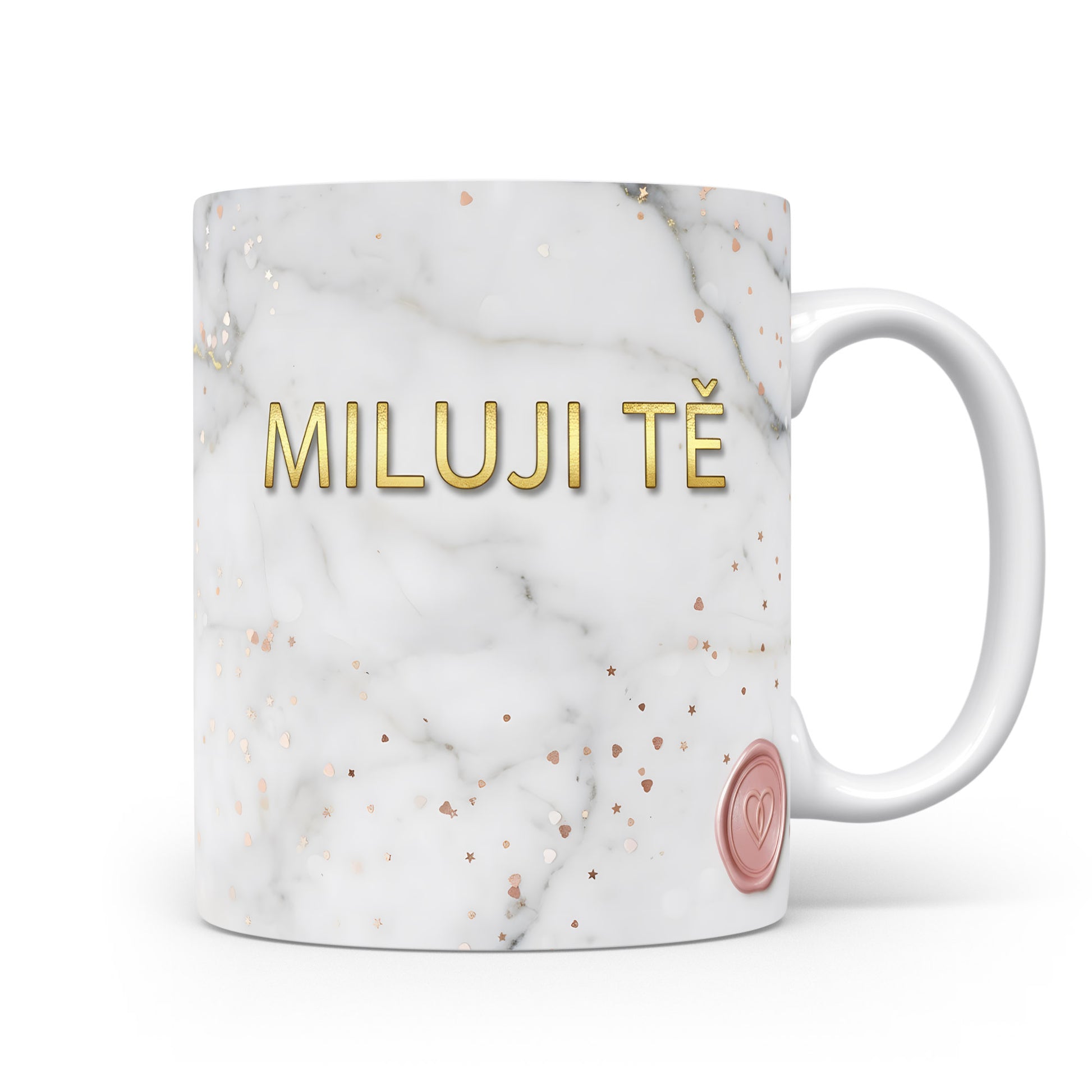 Bílý hrnek s nápisem MILUJI TĚ na mramorovém pozadí se zlatými srdíčky.
