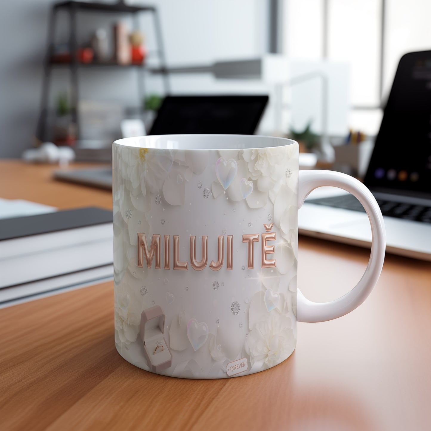 Bílý hrnek s nápisem MILUJI TĚ a květinovým motivem.