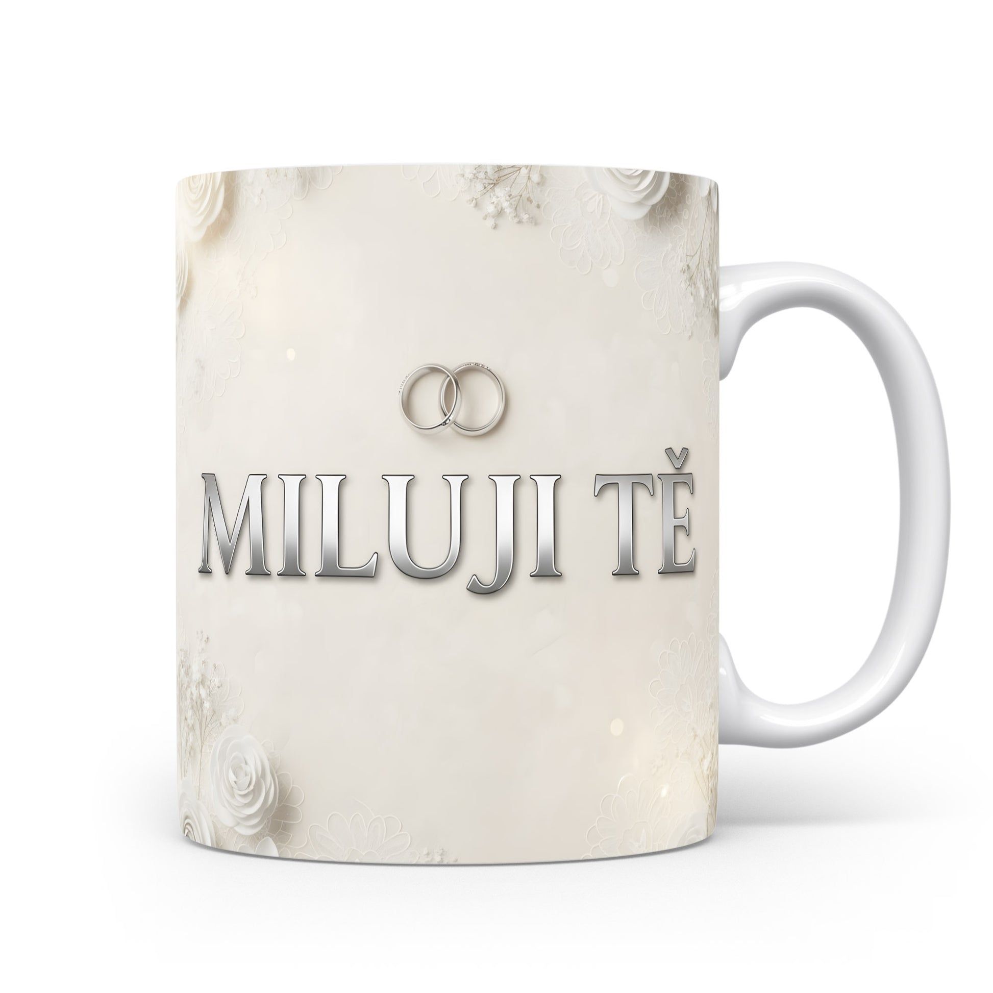 Bílý hrnek s nápisem MILUJI TĚ a květinovým motivem.