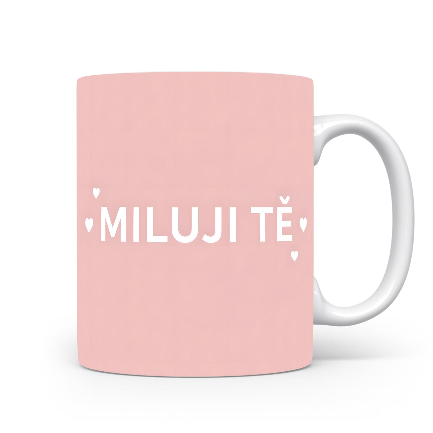 Růžový hrnek s nápisem MILUJI TĚ a malými srdíčky.