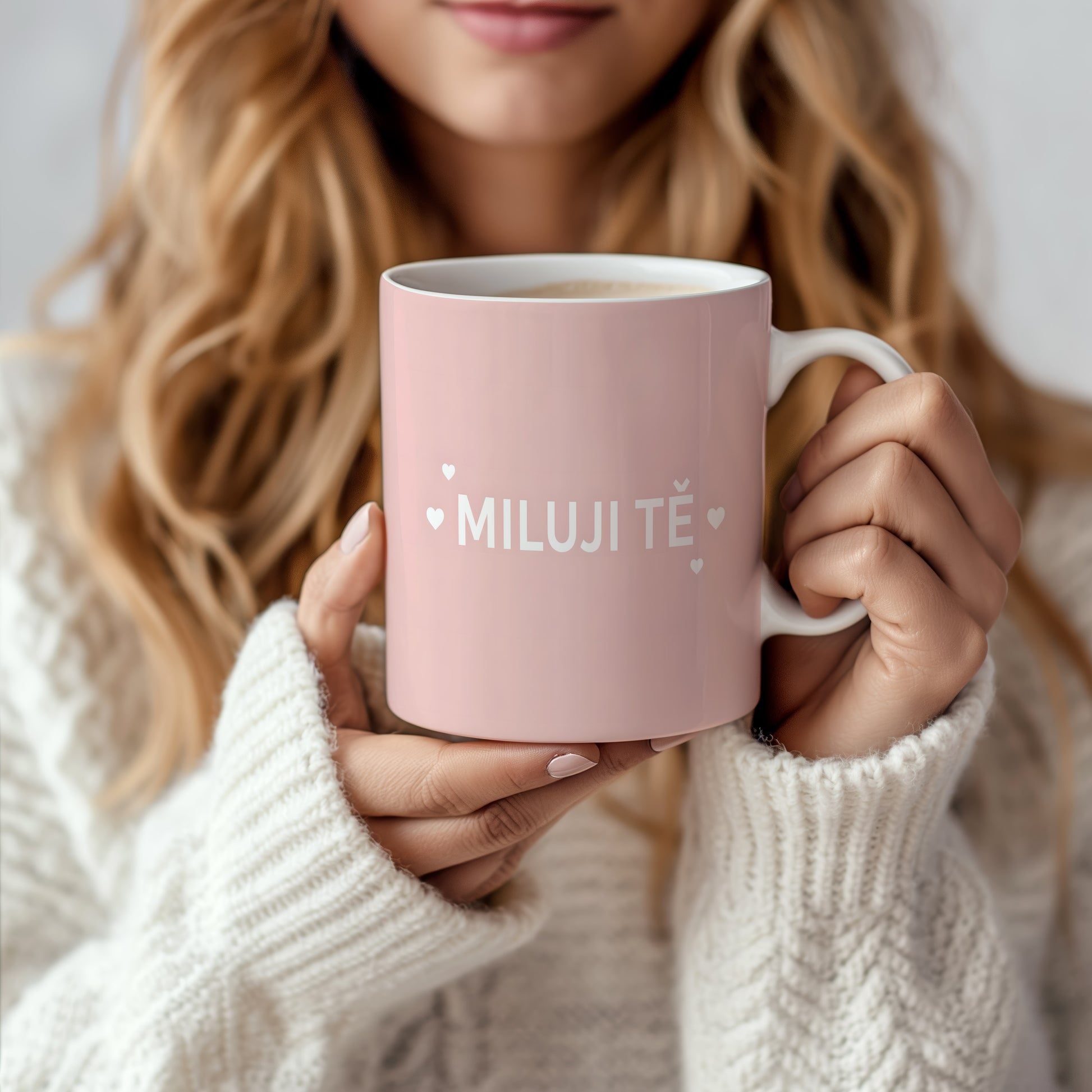 Růžový hrnek s nápisem MILUJI TĚ a malými srdíčky.