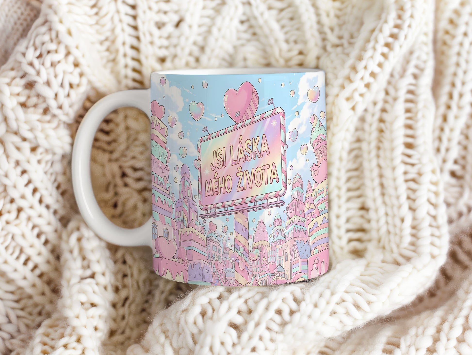 Pastelový hrnek s nápisem JSI LÁSKA MÉHO ŽIVOTA obklopený srdíčky a městem.